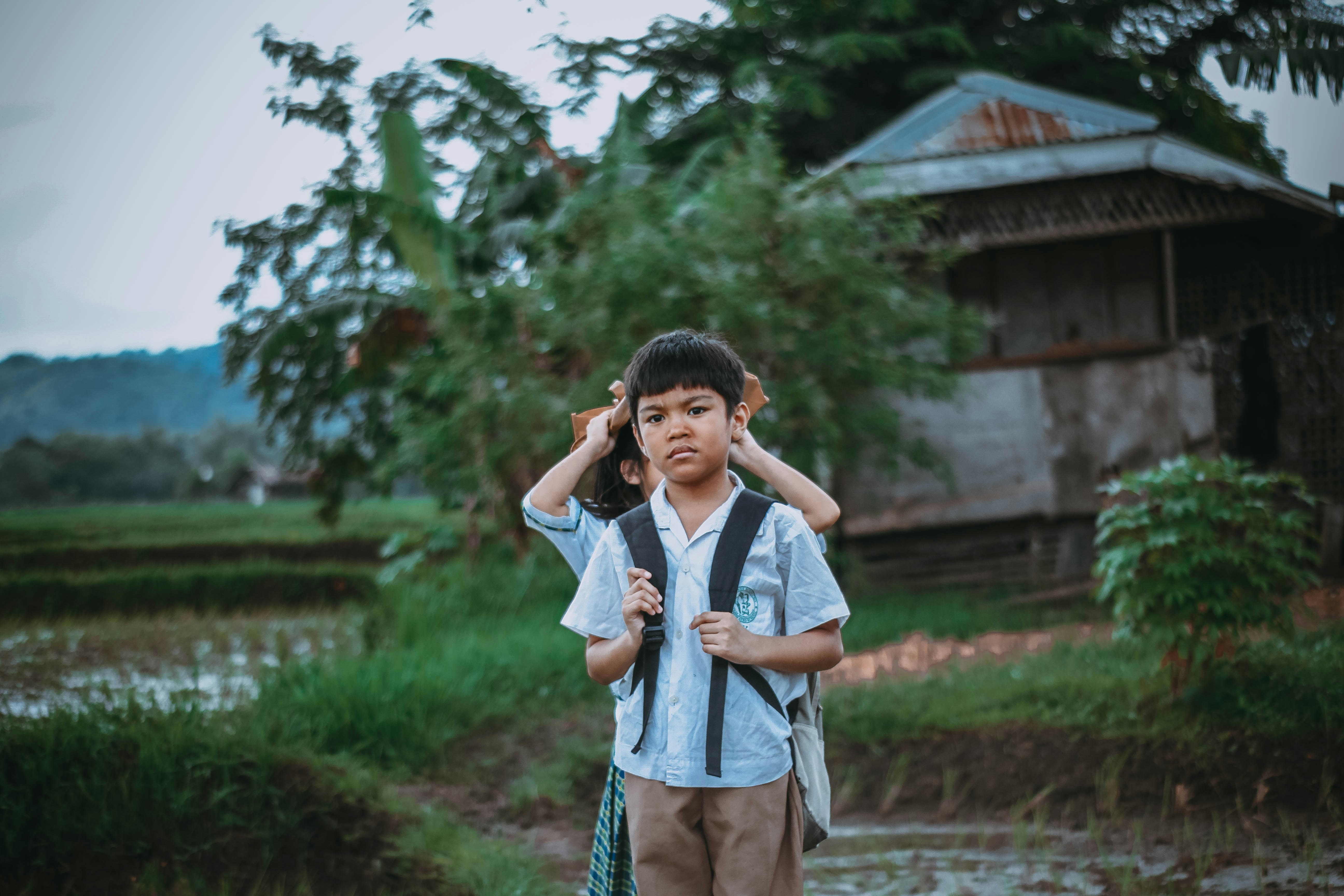 School boy with backpack in rural setting